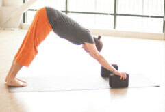 woman doing downward dog with blocks